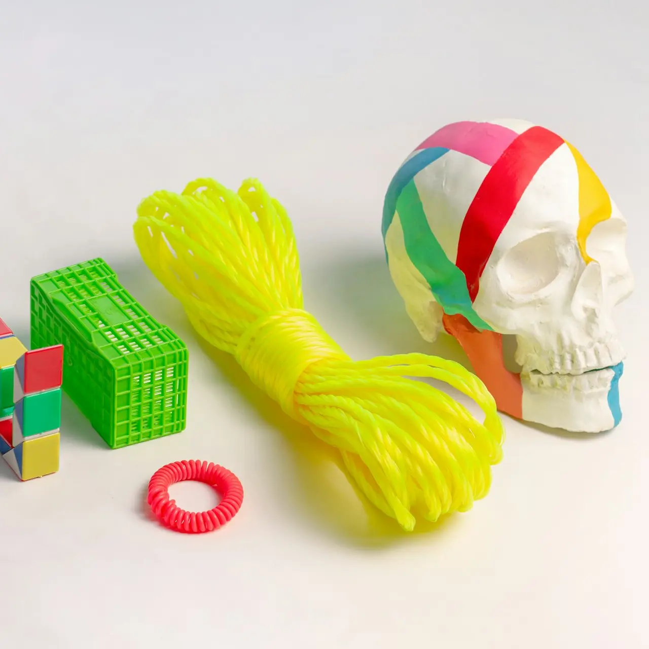 a skull, a ball of yarn, and a ring on a white surface